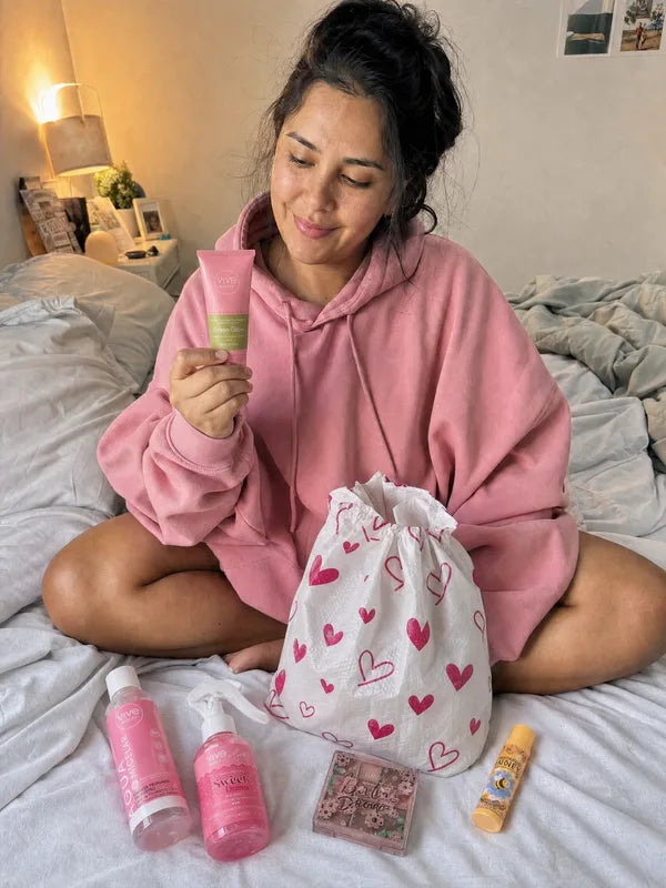 Mujer sentada en la cama mirando una crema que le salió
