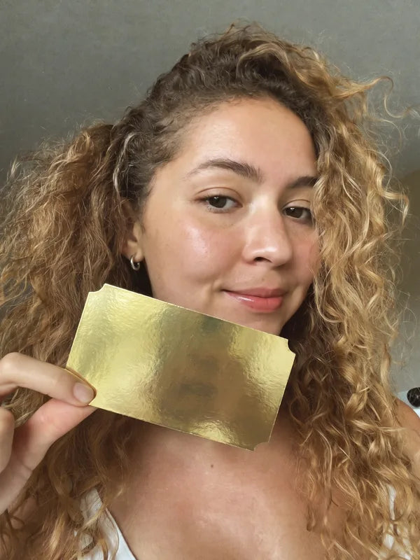 Mujer sonriendo con el boleto dorado de La Dorada en la mano